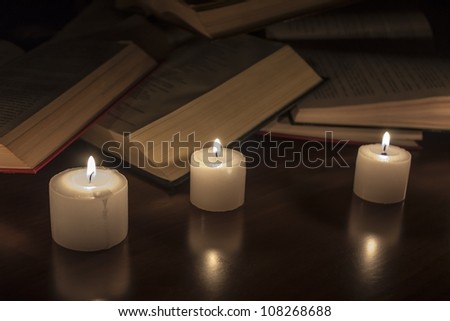 open books and candles on wood table