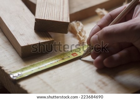 close up of carpenter hands measuring wood