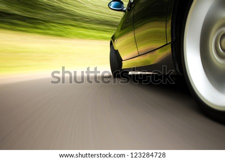 Side rear view of black sport car with heavy blurred motion