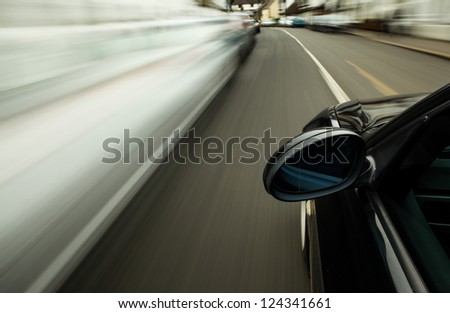 Side view of black car driving on street