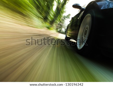 Front side view of black car driving fast.