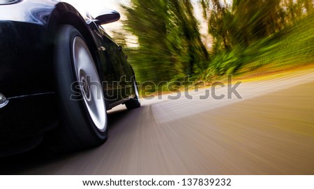 Front side view of black car with heavy blurred motion.