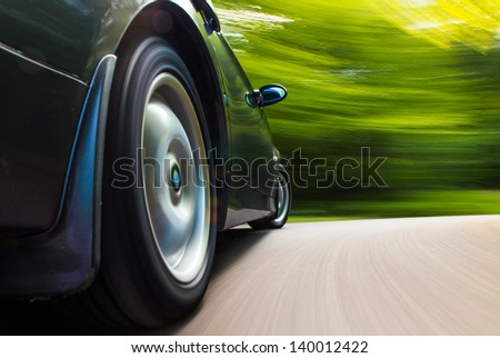 Rear side view of black car in turn with heavy blurred motion.