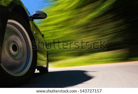 Front side view of black car in turn with heavy blurred motion.