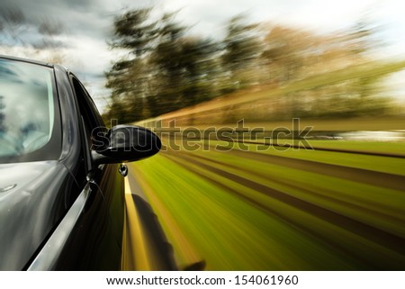 Mirror view of fast driving car.