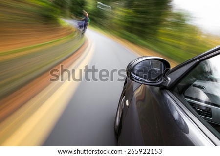 Mirror view of driving car in forest.