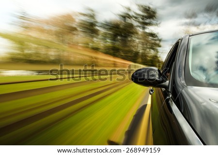unfocused Mirror view of speeding car.