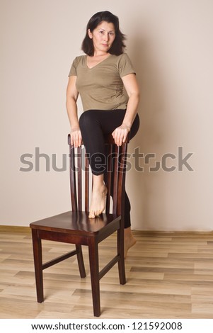 Woman performing fitness exercises with a chair
