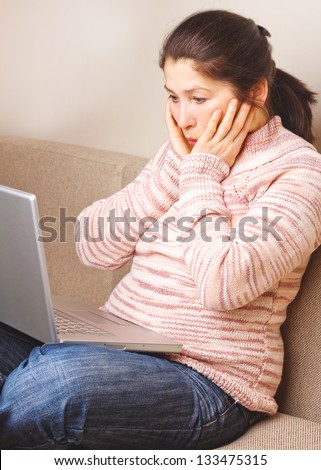Senior woman with  laptop, relaxing on the couch.