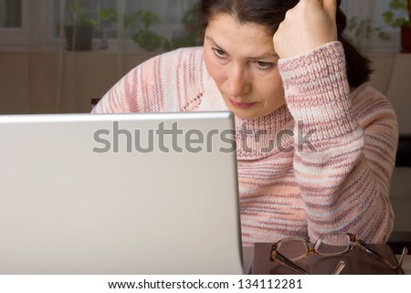 Senior woman with laptop, relaxing on the couch.