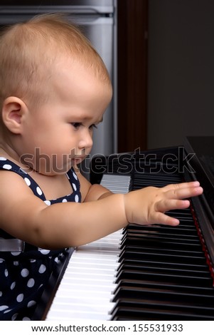 Beautiful baby girl plays piano
