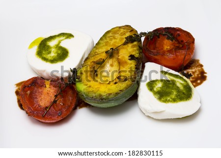 Grilled avocados, tomatoes and feta cheese and garnished with  sauce