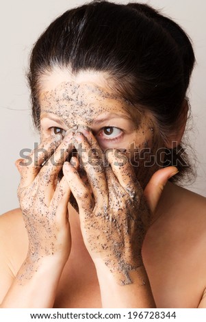 Mature woman making  cosmetic mask from coffee, sour cream.