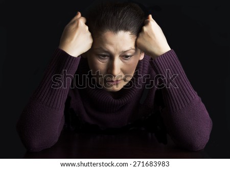 Sad elderly woman on a black background