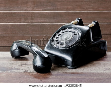 Old black telephone on wood table