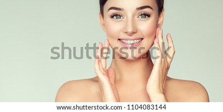 Face of a young woman with braces on her teeth . Healthy smile