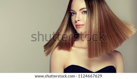 Beautiful model girl with shiny brown and straight long  hair . Keratin  straightening . Treatment, care and spa procedures. Medium length hairstyle. Coloring, ombre, shatush, balage and highlighting