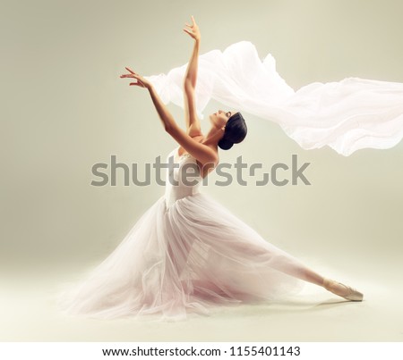 Ballerina. Young graceful woman ballet dancer, dressed in professional outfit, shoes and white  weightless skirt is demonstrating dancing skill. Beauty of classic ballet.