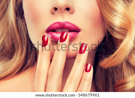 woman with red manicure .  girl with red nail Polish on the nails . Makeup and cosmetics