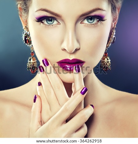 Fashion Girl Portrait . Beautiful girl model with purple makeup and manicure  on the nails .