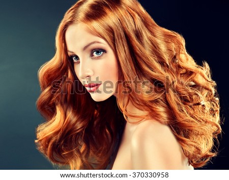 Beautiful model with long curly red hair .  Styling hairstyles curls