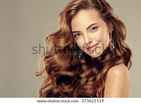 Beautiful girl with long wavy hair .  Brunette  model with curly hairstyle