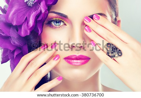 A fashion image model .Trend bright pink makeup . Stylish model girl with pink manicure nails and with  clip on his head .
