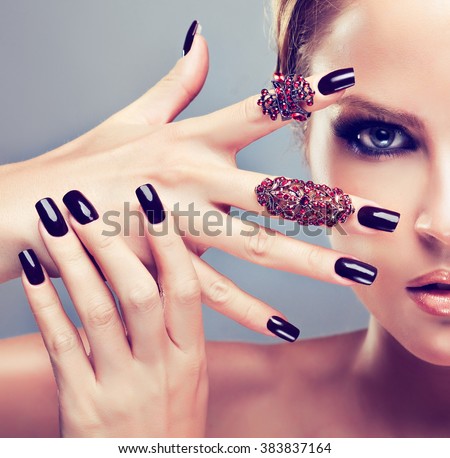 Model  girl  with burgundy manicure  nail and fashion jewelry   rings  . Beauty , fashion and cosmetics
