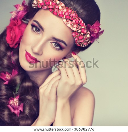 Spring model with flowers in her hair and fashion makeup . Summer girl with trendy make up and hairstyle .