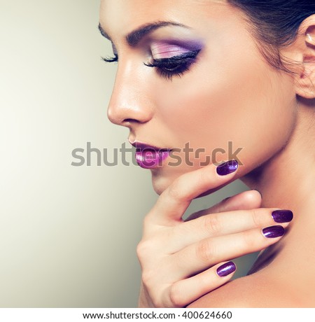 Beauty girl model with violet manicure  on the nails. \
Cosmetics and cosmetology .