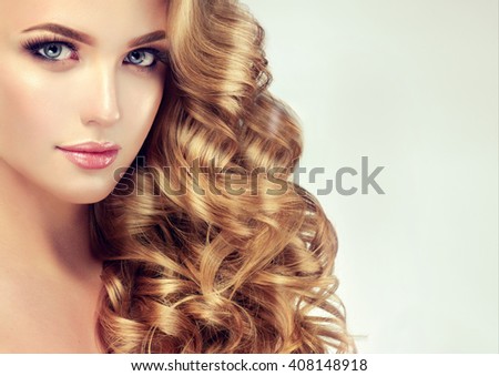 Blondel girl with long wavy hair .  Beautiful  model with curly hairstyle