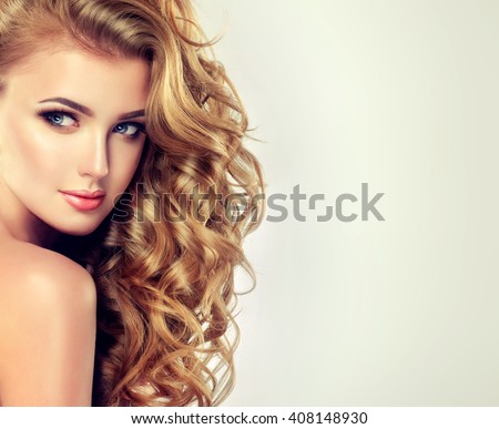 Blondel girl with long wavy hair .  Beautiful  model with curly hairstyle