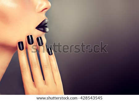 Beautiful girl showing black manicure nails . makeup and cosmetics