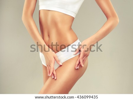 Perfect slim toned young body of the girl . An example of sports , fitness or plastic surgery and aesthetic cosmetology.