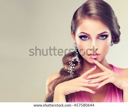 Beautiful model girl with elegant hairstyle . Woman with fashion wedding hair  . Cosmetics, beauty and manicure on nails