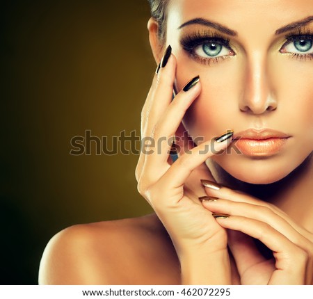 Beautiful model girl with  Golden makeup and gold  metal manicure  nails.  Fashion woman Portrait