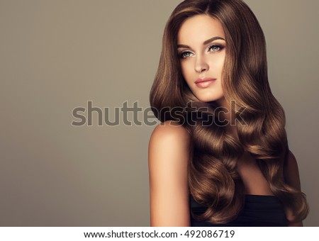 Beautiful girl with long wavy  and shiny  hair . Brunette woman  with curly hairstyle