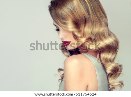 Beautiful girl with long wavy hair .  Blonde with curly hairstyle and red lips