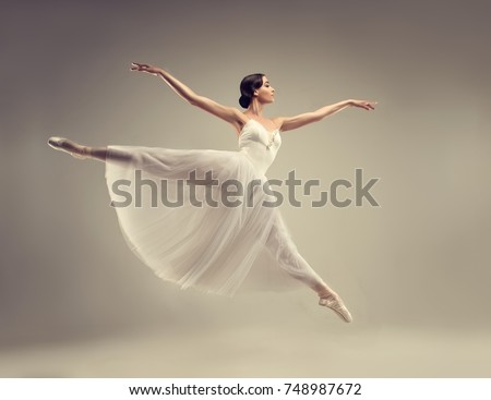Ballerina. Young graceful woman ballet dancer, dressed in professional outfit, shoes and white  weightless skirt is demonstrating dancing skill. Beauty of classic ballet.
