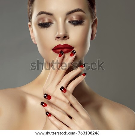 Beautiful model girl with red and black  french manicure on nails . Fashion luxury makeup . Dark red lips and shiny eye shadow pigment . Beauty  and cosmetics .