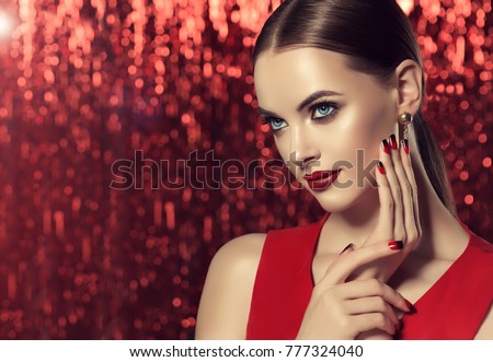 Beautiful model girl with red and black  french manicure on nails . Fashion luxury makeup . Dark red lips and shiny eye shadow pigment . Beauty  and cosmetics . Red shiny background .