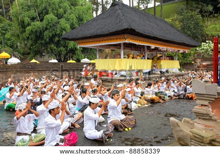 TAMPAK SIRING, BALI, INDONESIA - OCTOBER 30: People praying at holy spring water temple Puru Tirtha Empul during the religious ceremony on October 30, 2011 in Tampak Siring, Bali, Indonesia