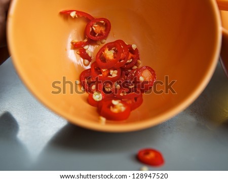 Hot red chili papers, spicy food, popular in Asia, orange plate with hot red chili papers close up and one blur chili on the table, mexican, spicy