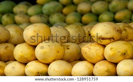 Fresh dirty isolated mango fruits in street market, close up, different kinds and colors mango fruits