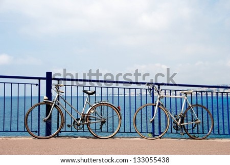 Two bicycles in the street with blue sky and blue see background in Nice, two bicycles ready for rent