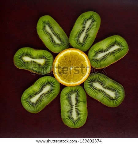 Many slices of kiwi fruit, kiwi fruit, kiwi fruit background with the orange slice in the middle, Fresh kiwis and orange fruit on dark background, interesting fruit composition, artistic fruits photo