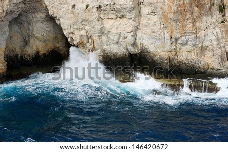 Wave breaking on the rocks in the sea,nice Blue Grotto view in Malta island close up, rock and water, Blue Grotto, view to the rock from the sea, popular,nice place in Malta,crystal sea water, nature