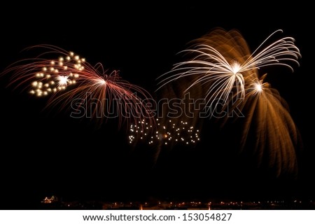 Colorful golden yellow fireworks with village silhouette in dark night background in Malta, fireworks explosion in dark sky background, Malta fireworks festival, 4 of July, explode, August 15
