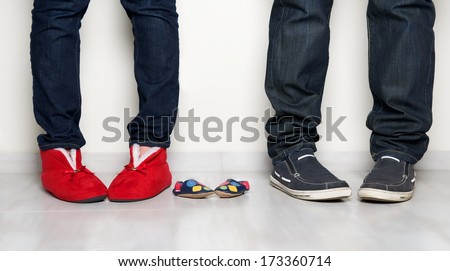 Young people family legs feet standing together, pretty woman,man legs and small baby shoes on light background, family photo close up, pregnancy fragment, maternity