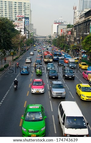 BANGKOK, THAILAND - JANUARY 14: street view with colourful cars on Jan 14, 2011. Daily life and traffic in Bangkok. Social issue of Bangkok, Thailand